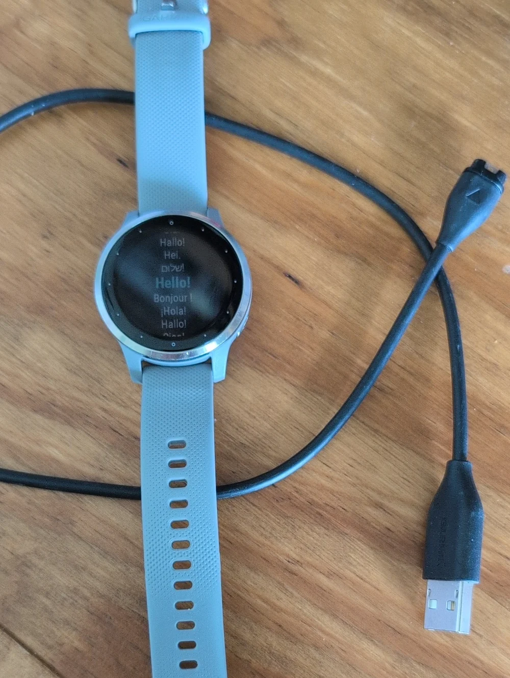 garmin round smartwatch with light gray strap and silver bezel